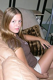 Cute Brunette Girl Sitting On The Couch